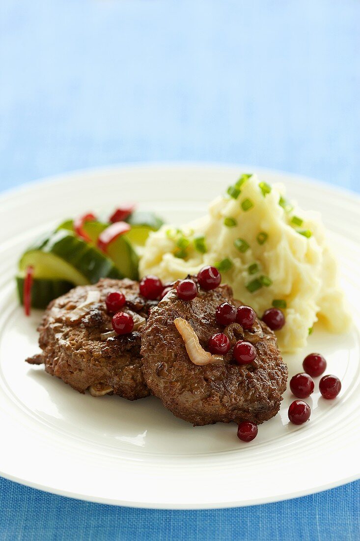 Burgers with mashed potato and chilli cucumber salad