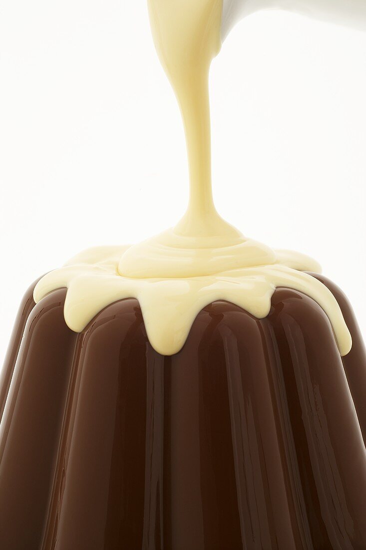 Schokoladenpudding mit Vanillesauce übergießen