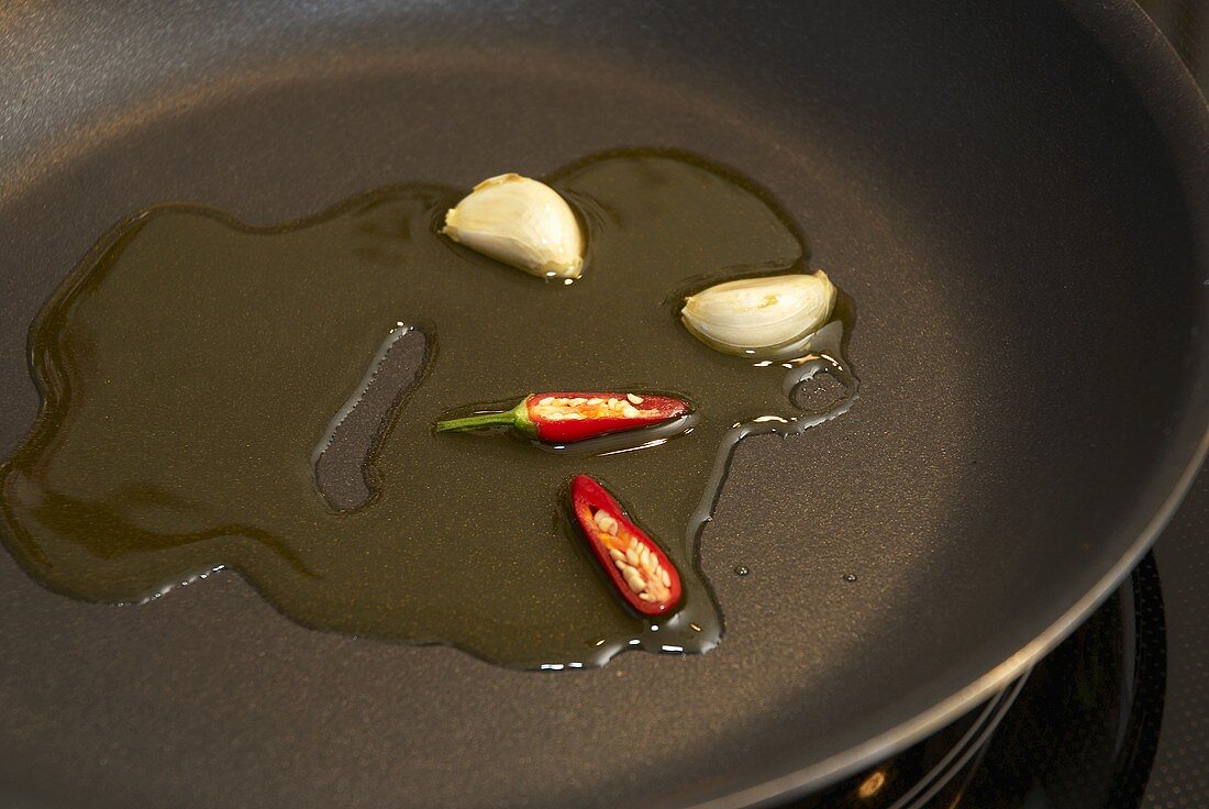 Sautéing chilli and garlic in a frying pan