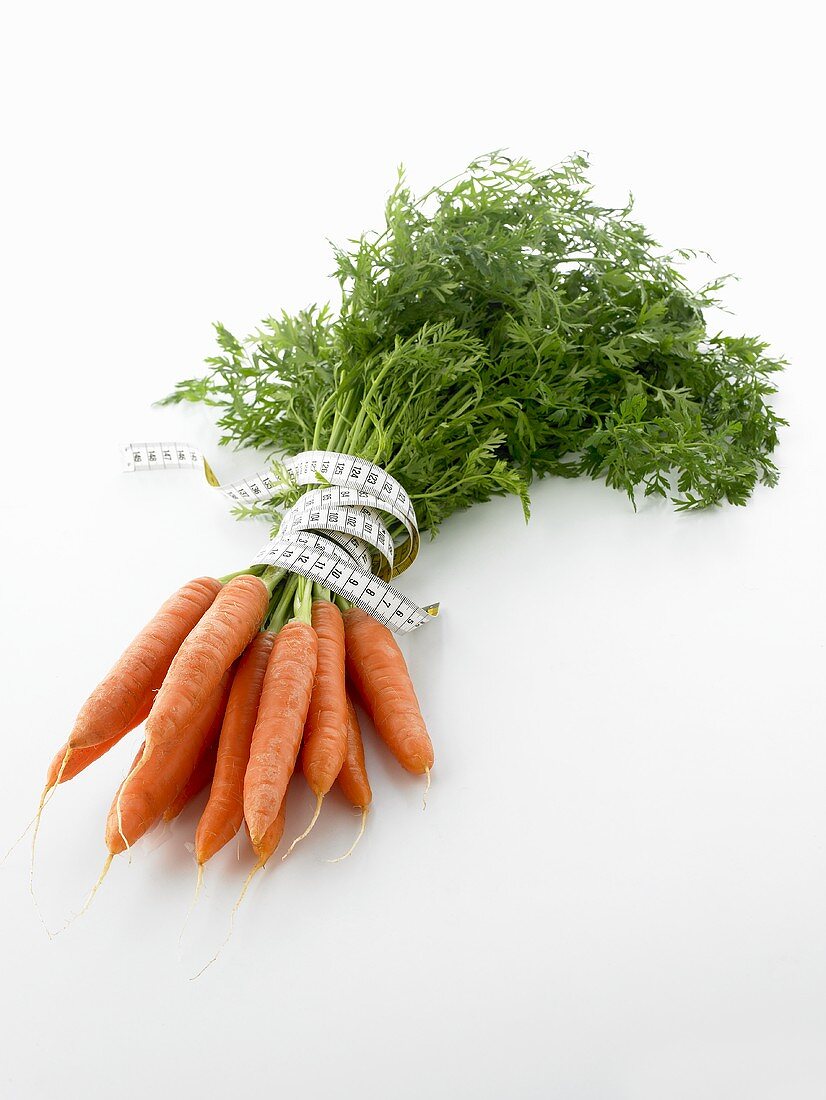 Fresh carrots tied together with tape measure