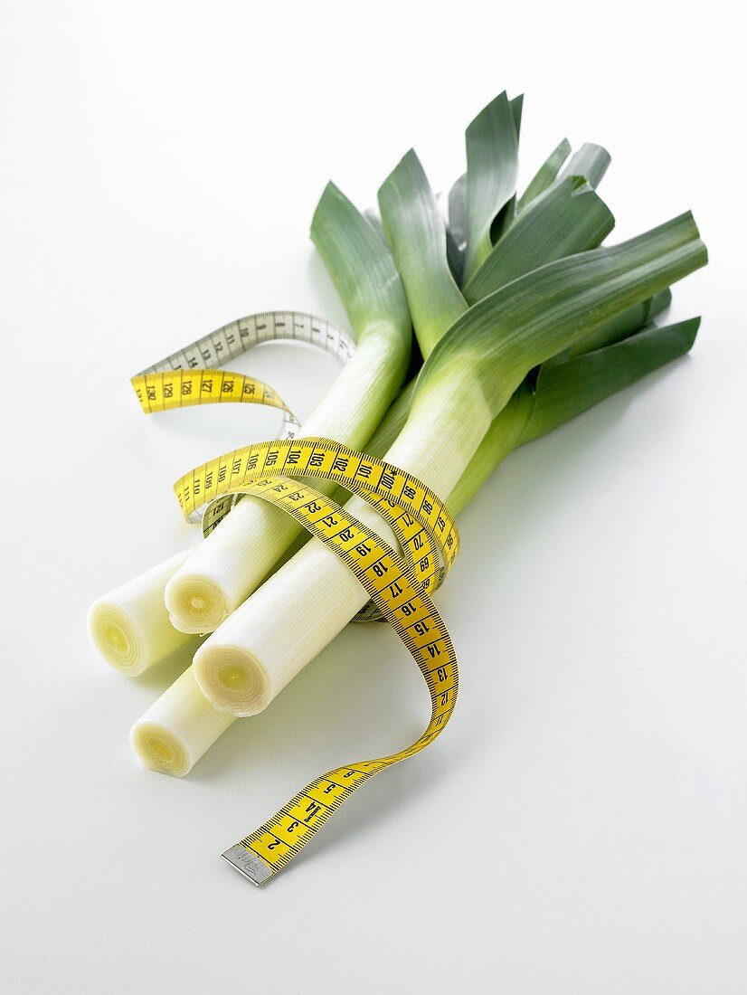 Four leeks with a tape measure wrapped around them