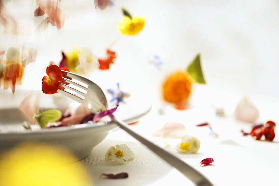 Flowers falling onto a plate with a fork