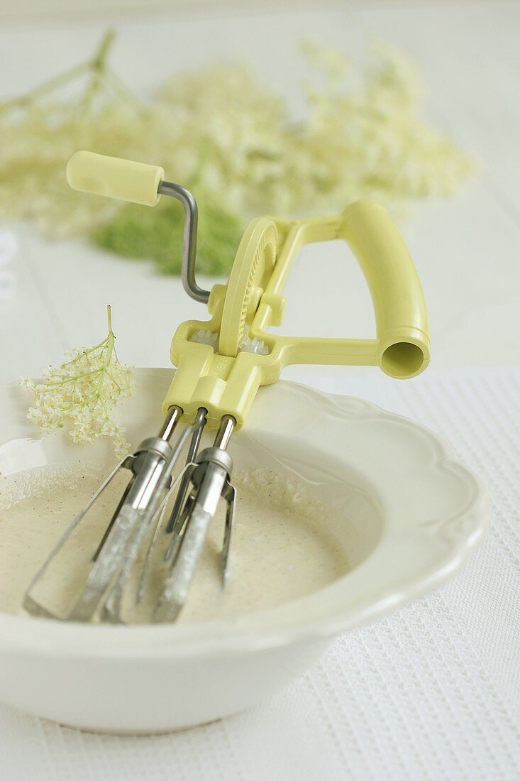 Batter for elderflower fritters in a small bowl