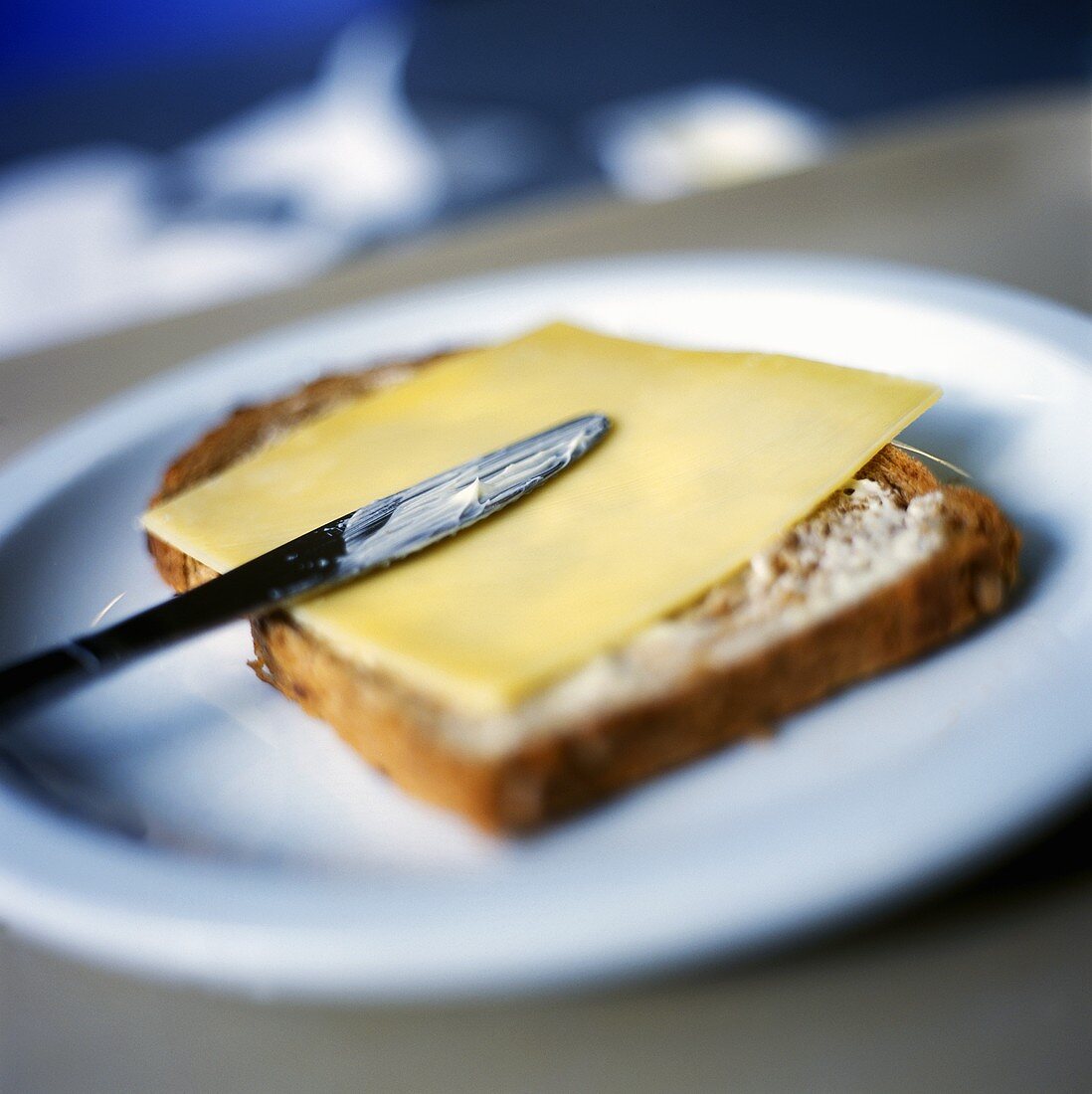Butterbrot mit einer Scheibe Käse und Messer
