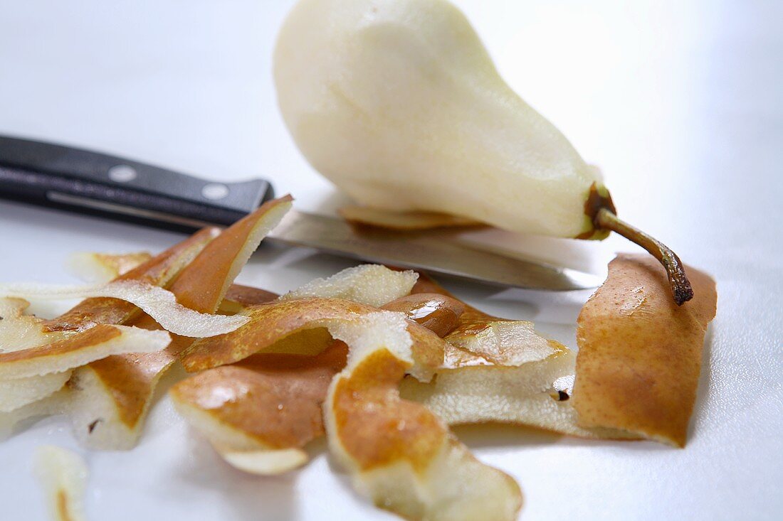 Peeled pear (variety 'Bosc's Flaschenbirne') with knife