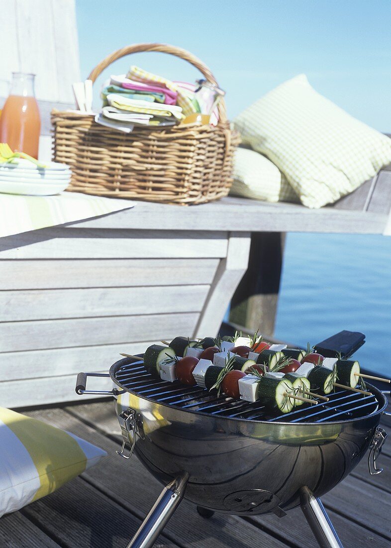 Picnic basket and barbecue on a landing stage