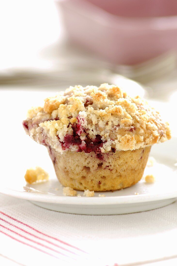 A cherry muffin with crumble topping
