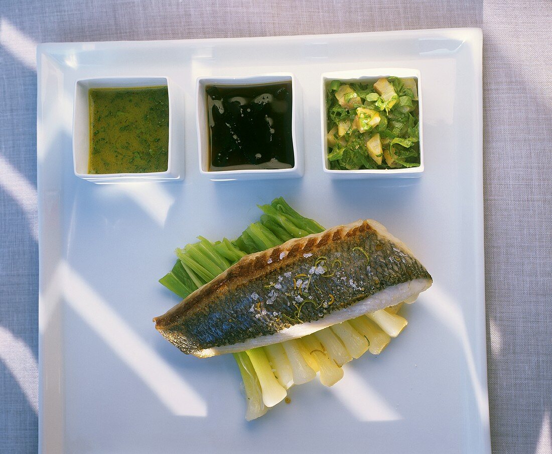 Fried sea bream fillet on spring onions with three sauces