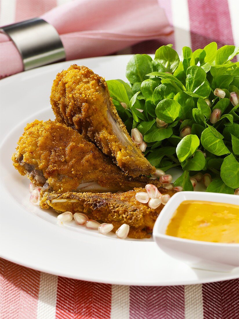 Breaded lamb chops with corn salad and pomegranate seeds