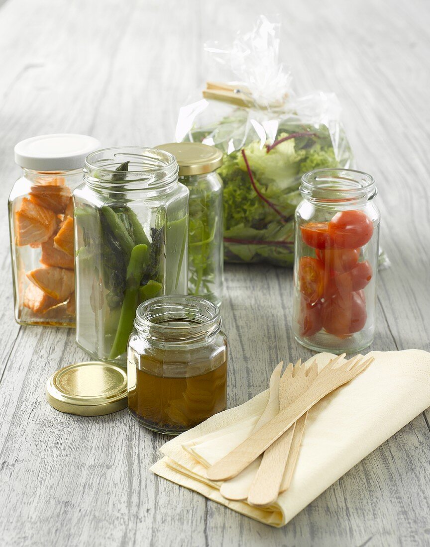 Verschiedene Salatzutaten in Gläsern fürs Picknick