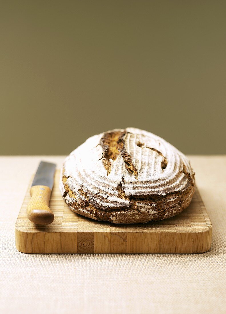 Bauernbrot (German farm bread) on wooden board with knife