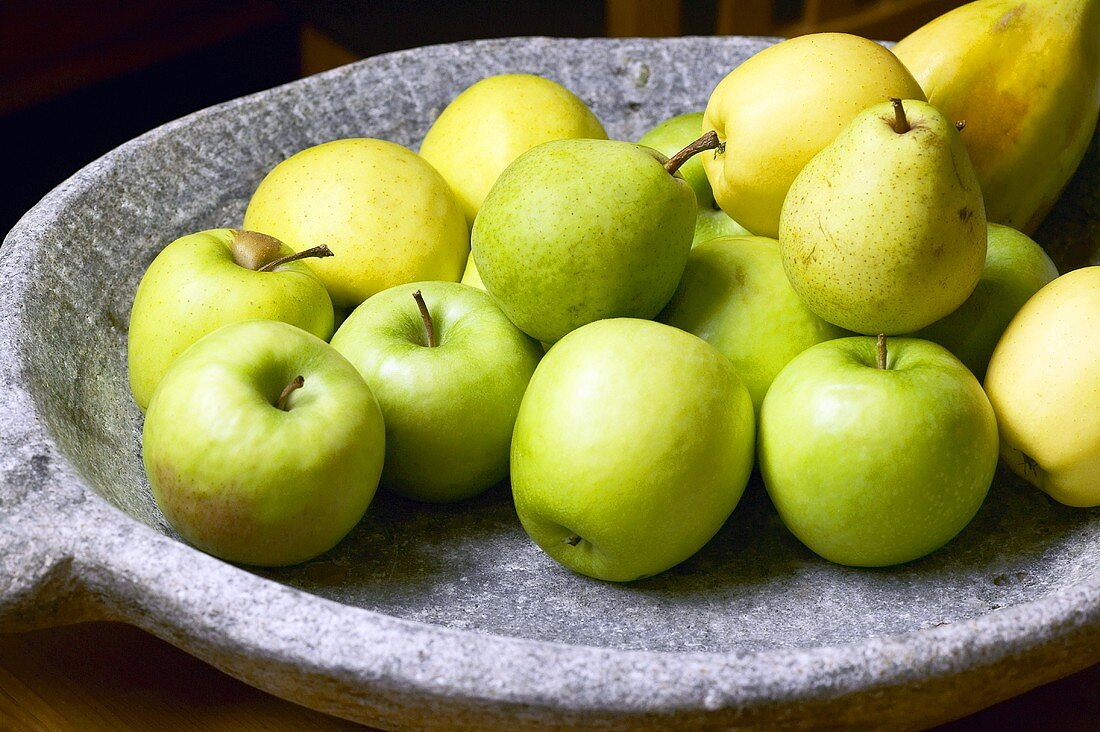 Äpfel und Birnen in einer Steinschale