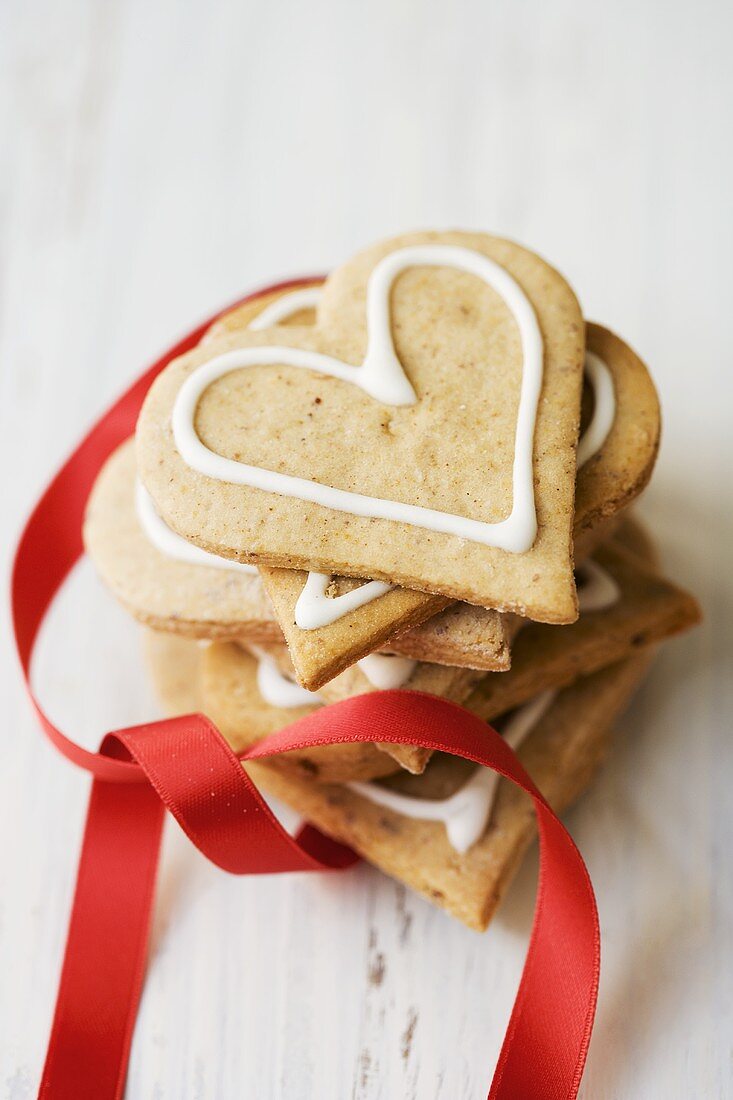 Pile of gingerbread hearts with red ribbon