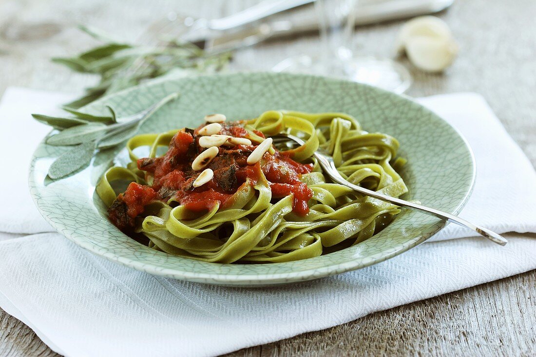 Spinach pasta with fried sage leaves in tomato sauce
