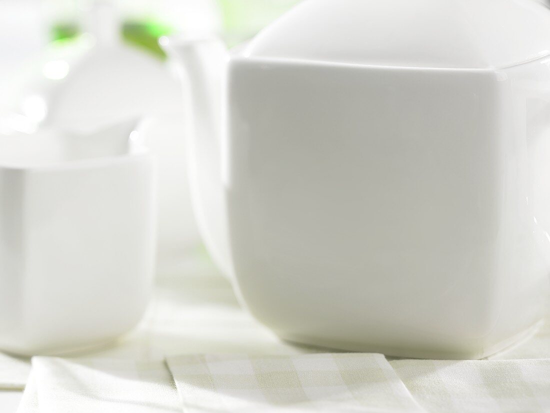weiße Teekanne mit Milchkännchen und Zuckerdose