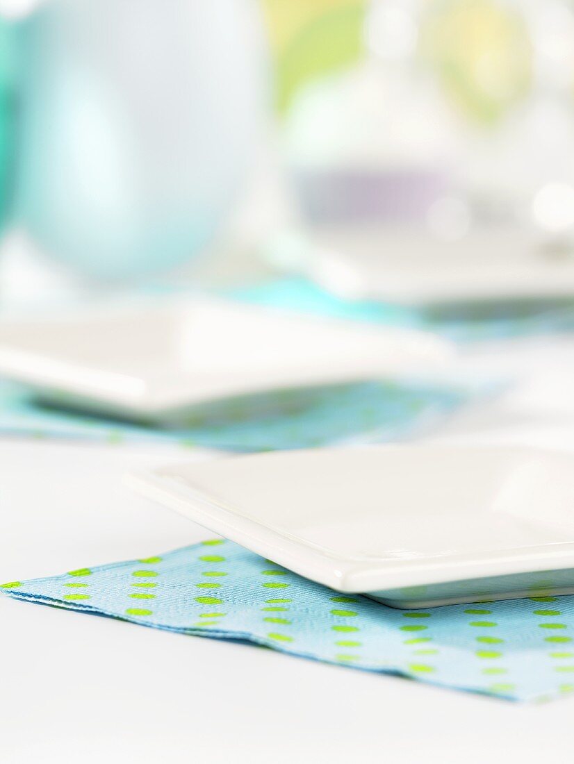 Zwei weiße Platten auf blau-grünen Servietten