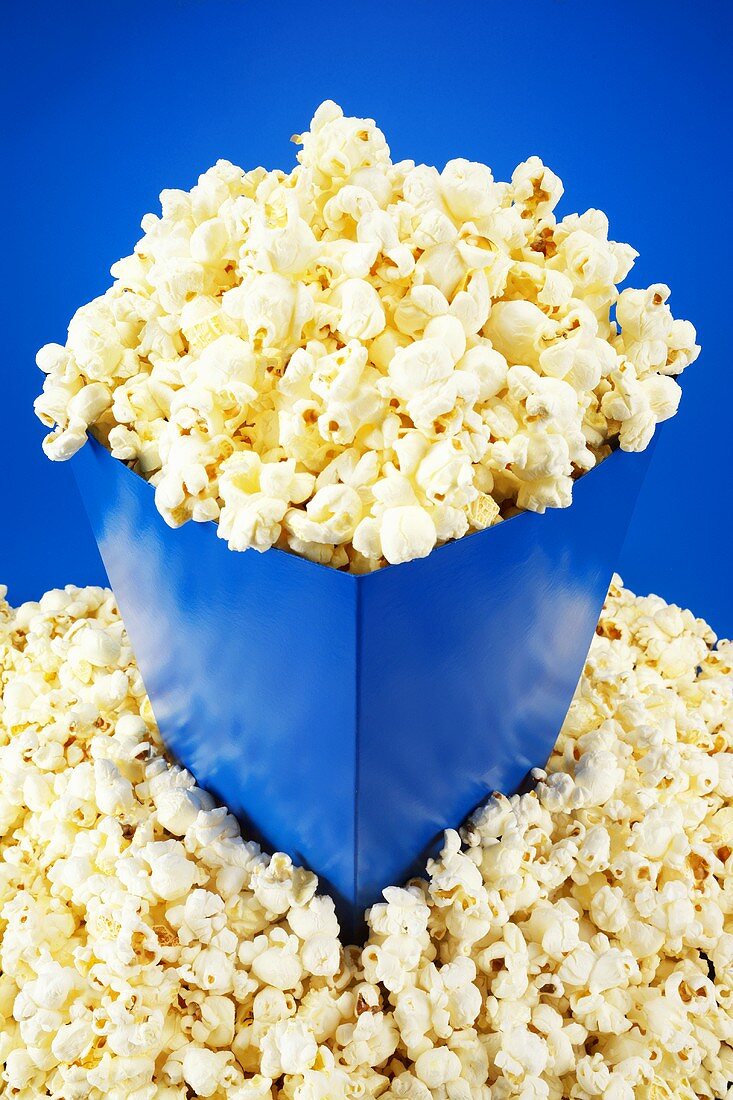 Popcorn in and around blue carton