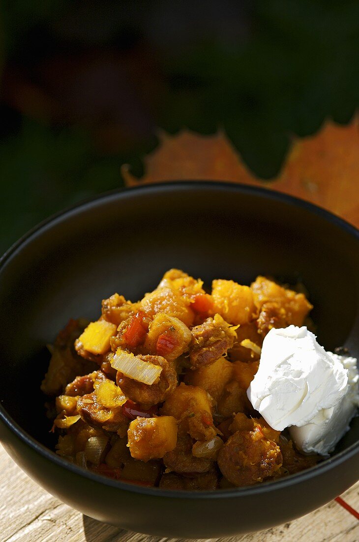 Pumpkin and vegetable stew with chorizo in small bowl
