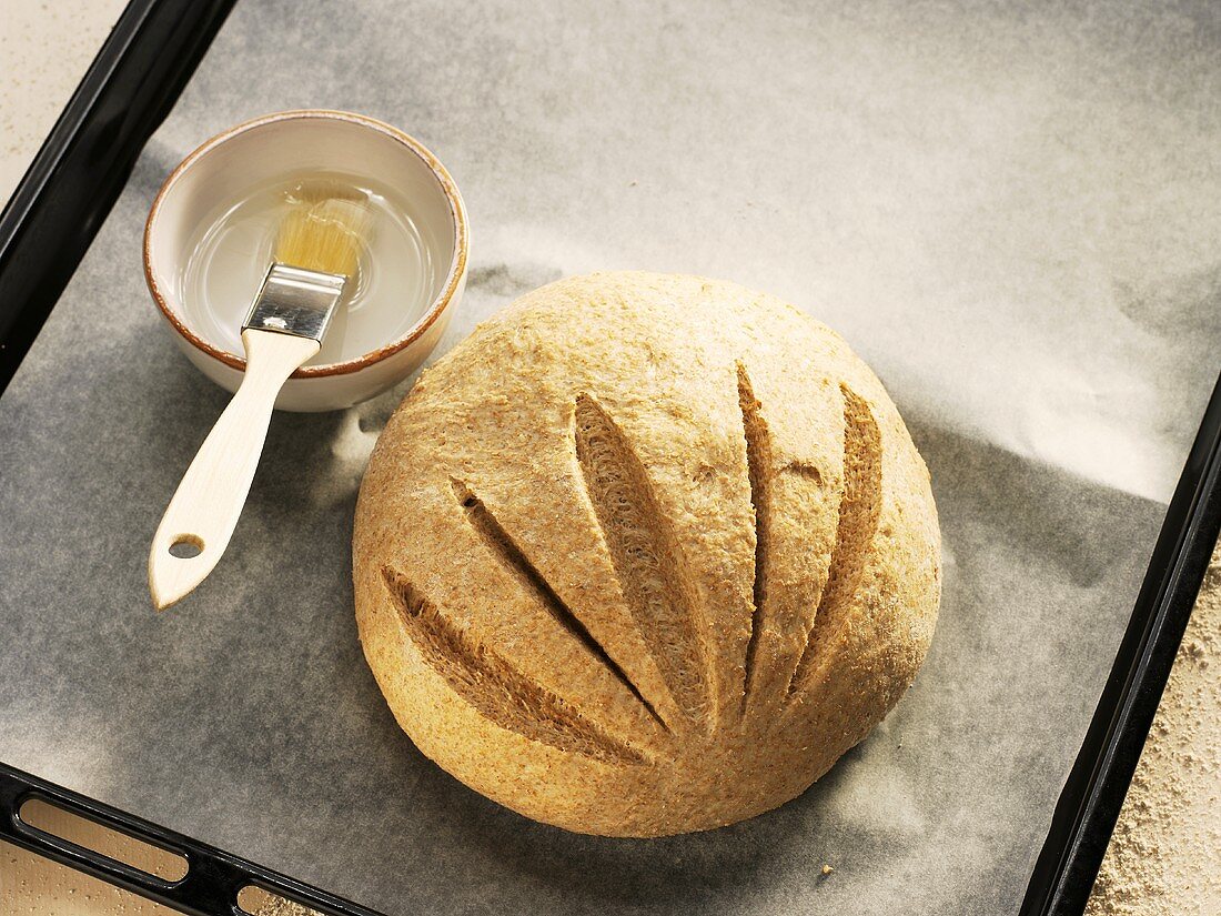 Brushing unbaked Hausbrot (rye bread) with water