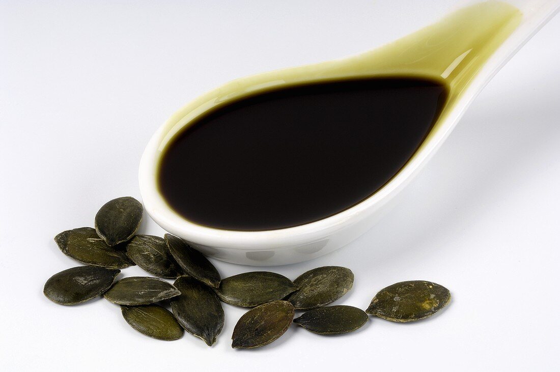 Pumpkin seed oil on a spoon with pumpkin seeds