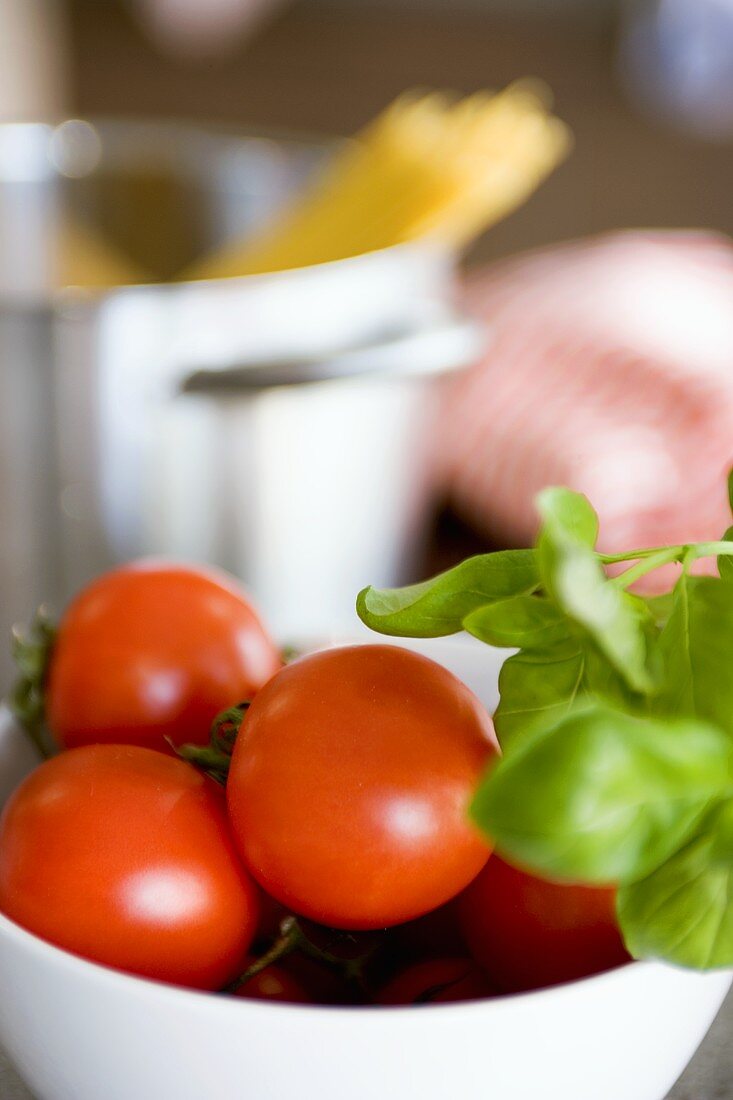 Fresh tomatoes in a small bowl and basil