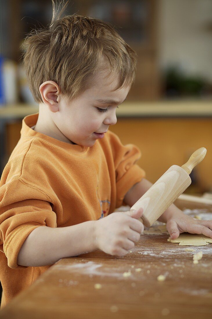 Small boy baking biscuits