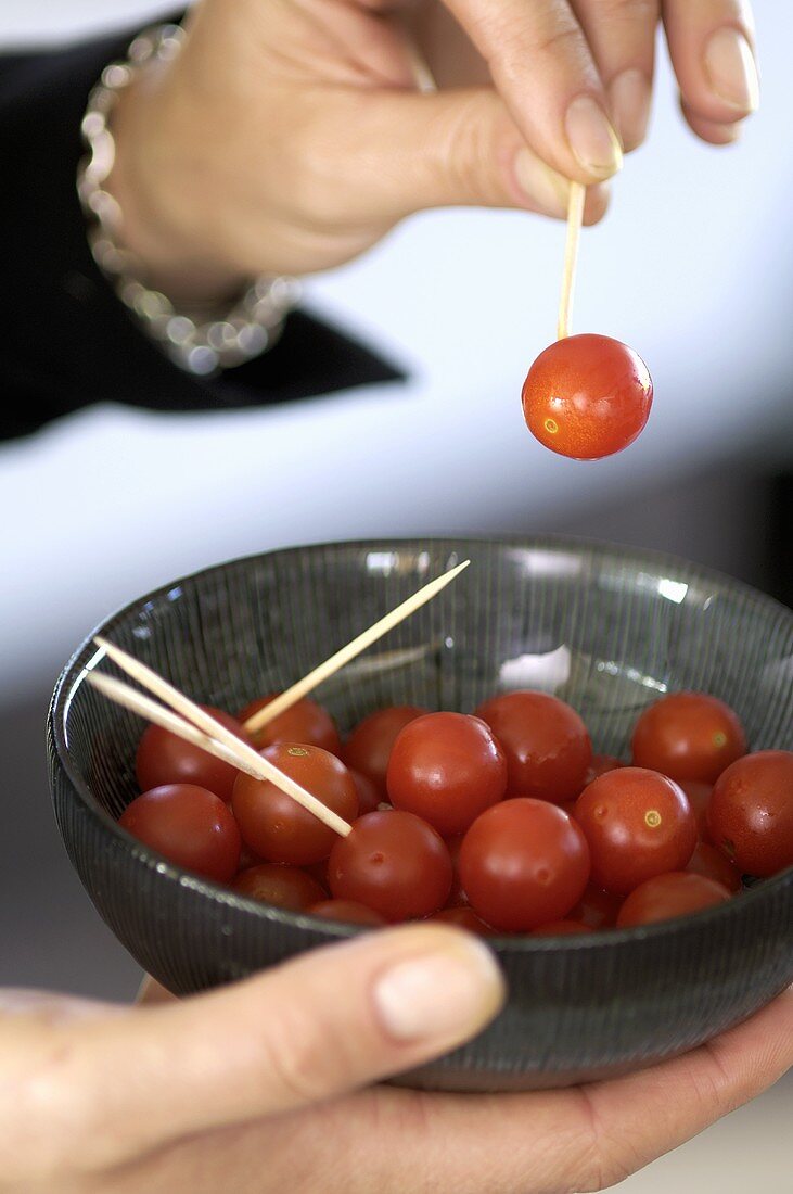 Cocktail tomatoes on cocktail sticks in a small bowl