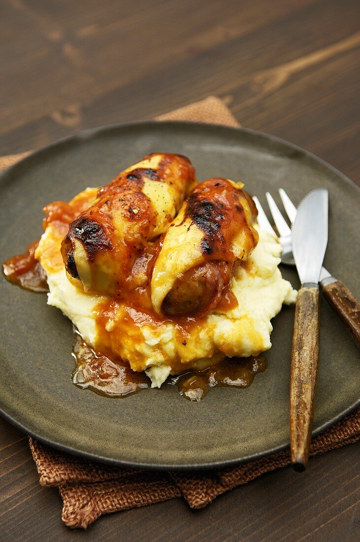 Sausages with sweet and sour topping on mashed potato