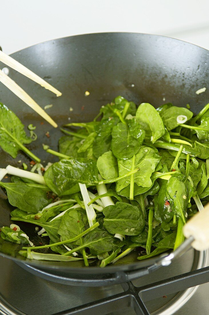 Sweating spinach in a wok