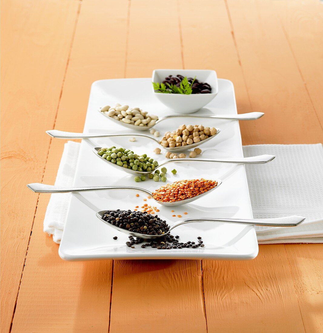 Various different pulses in spoons on platter