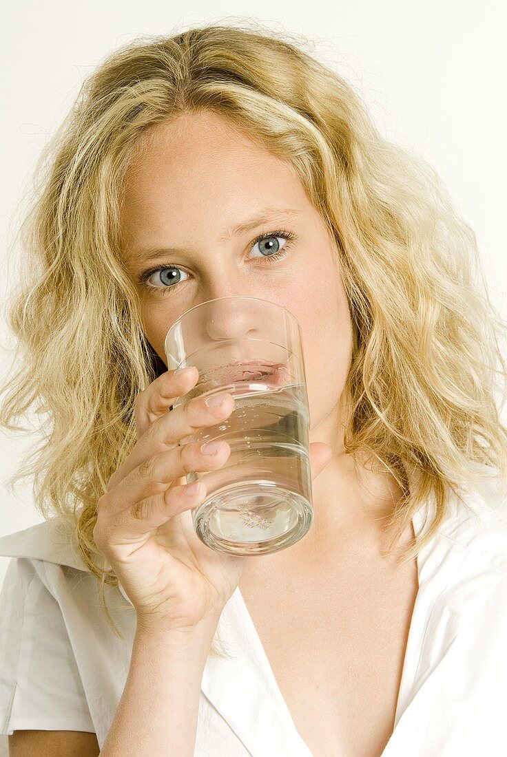 Junge Frau trinkt Wasser aus einem Glas