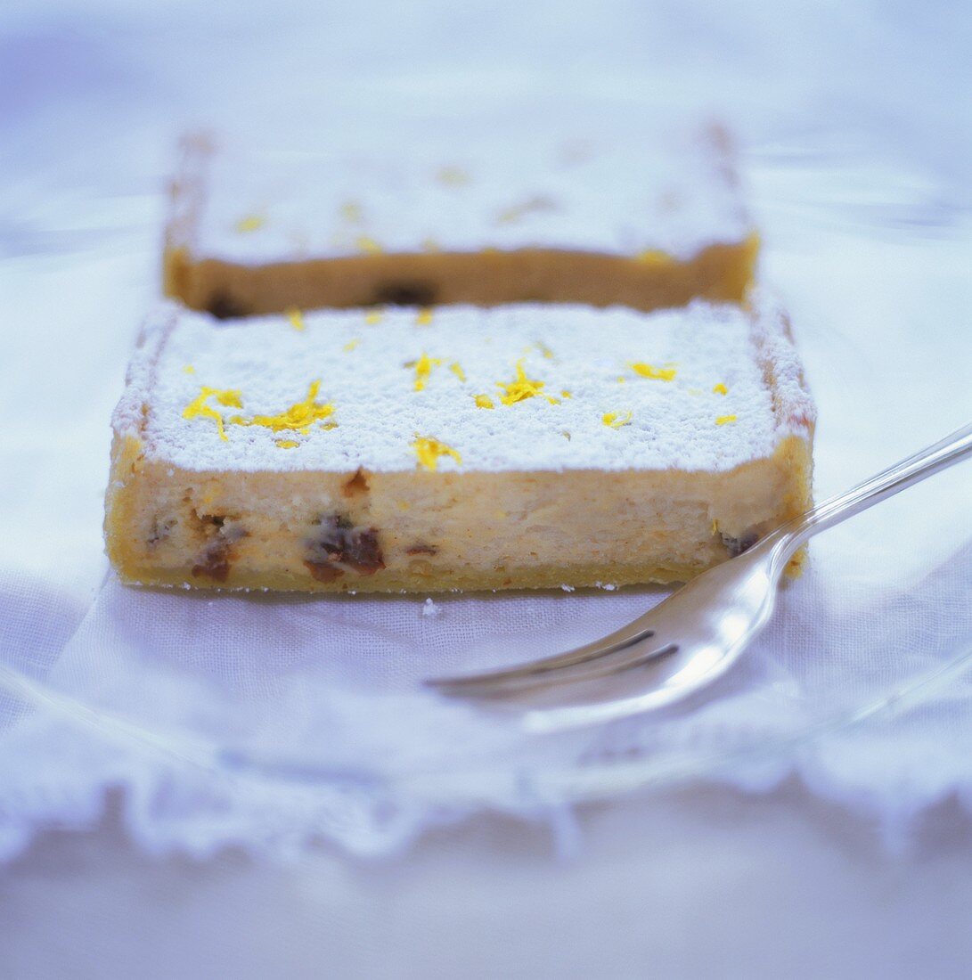 Two pieces of Eierschecke (type of cheesecake) with icing sugar