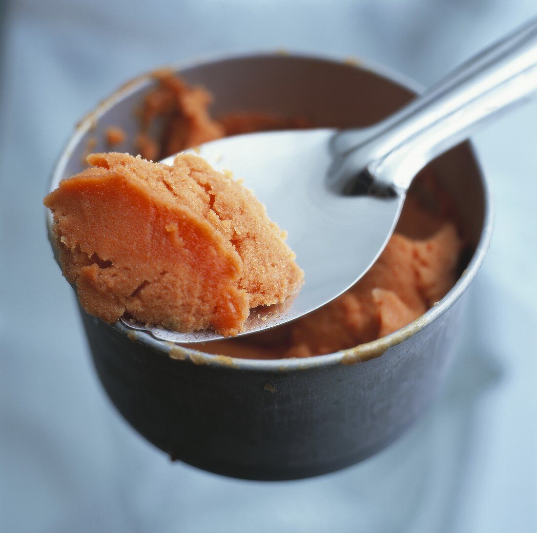 Papaya sorbet in small bowl with spoon