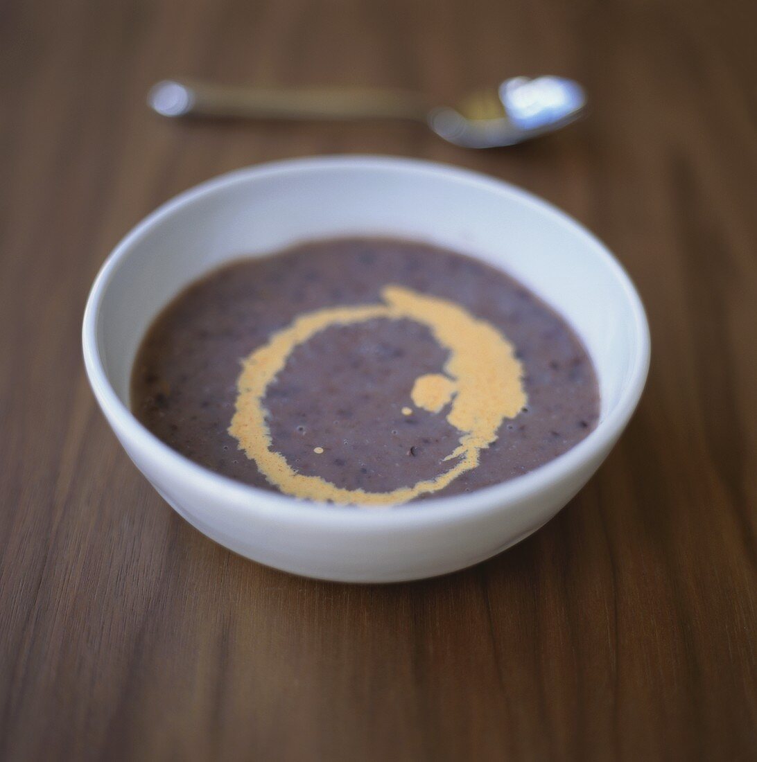 Heidelbeersuppe mit Mandelblättchen, Sahne und Minze in Tasse