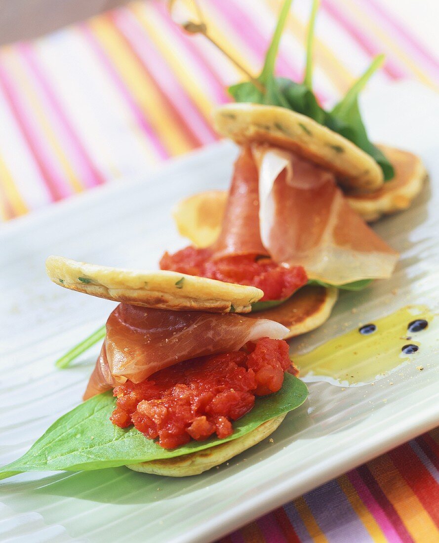 Corn blinis with spinach, tomato puree and ham