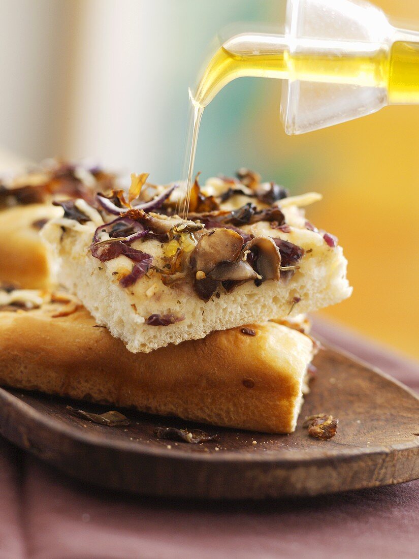 Drizzling focaccia with olive oil