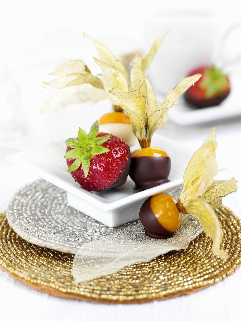 Chocolate-coated physalis and strawberries