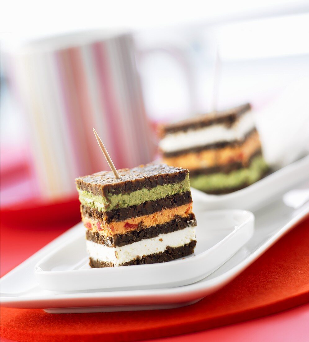 Triple-decker pumpernickel squares with various spreads