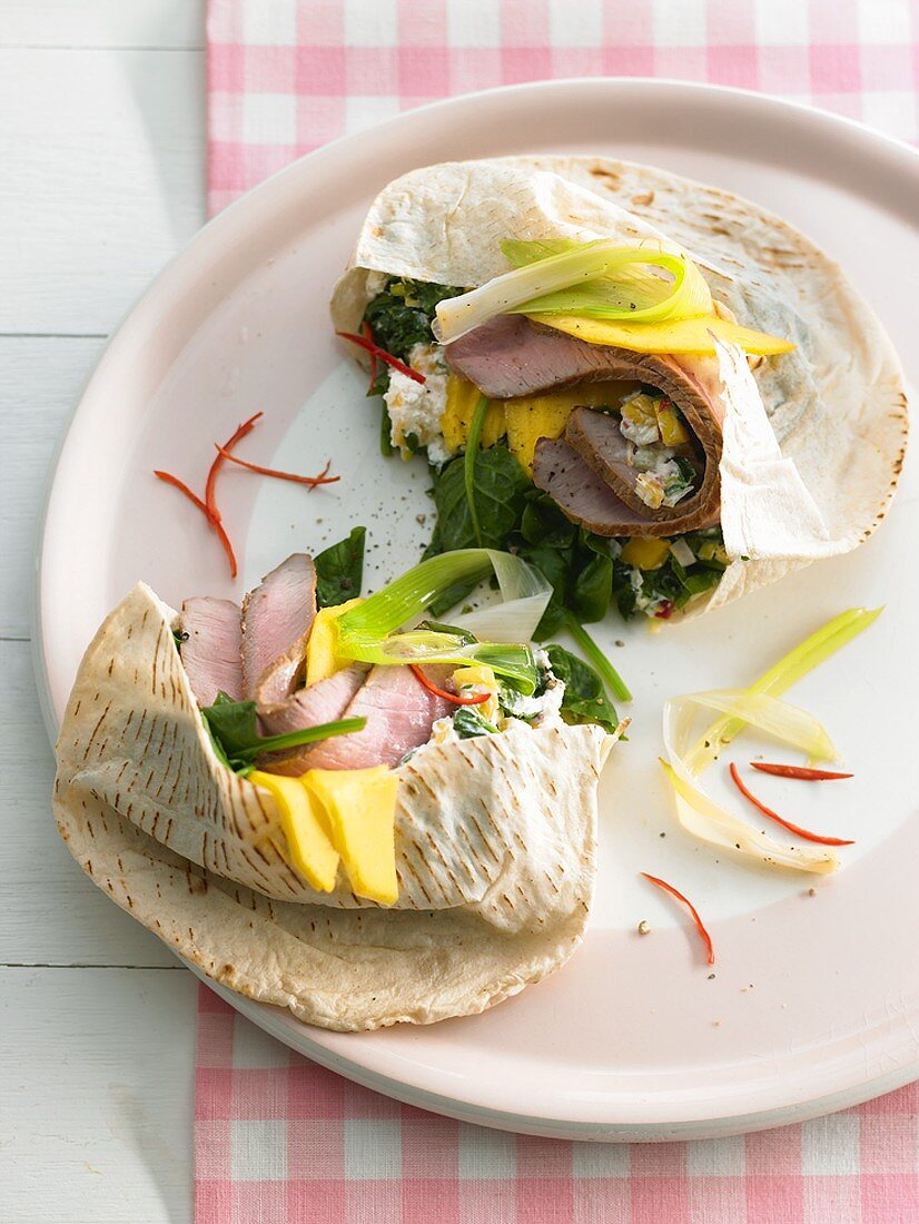Pita bread filled with pork fillet, mango and spinach