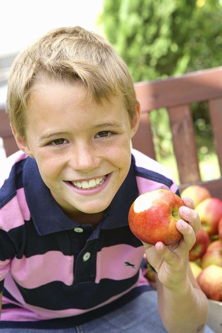 Junge mit angebissenem Apfel in der Hand