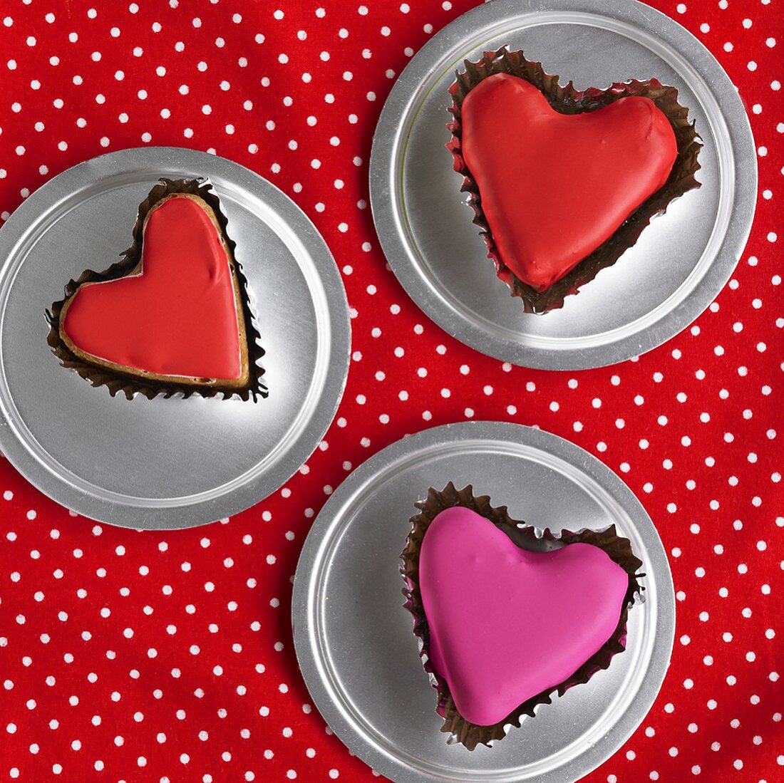 Three heart-shaped iced cakes