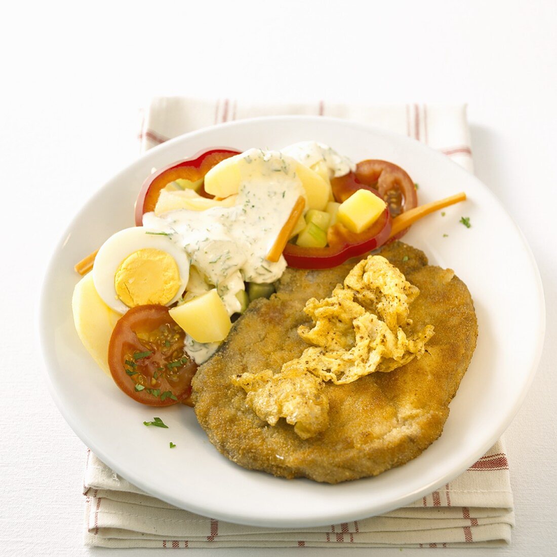 Breaded chop with colourful potato salad