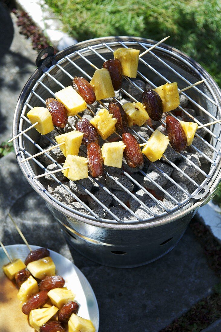 Pineapple and date kebabs on barbecue