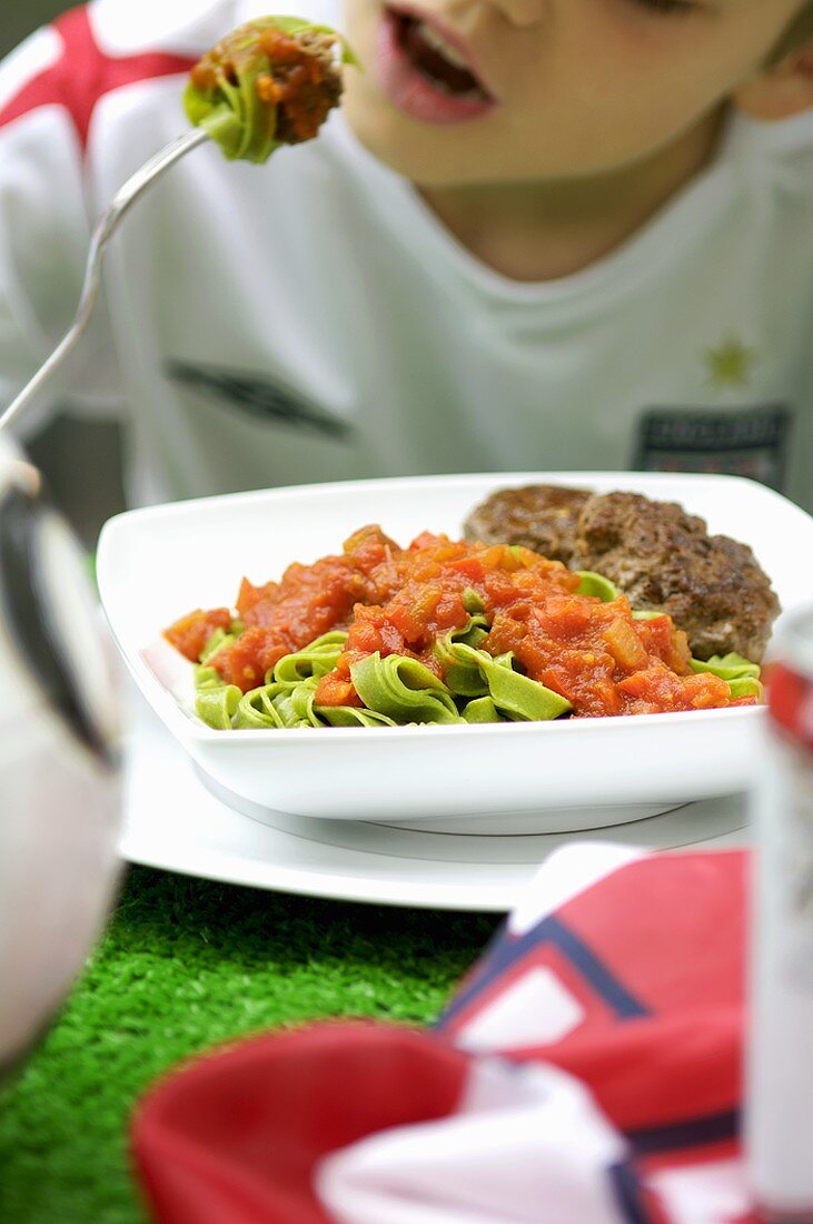 Grüne Bandnudeln mit Tomatensauce und Frikadellen