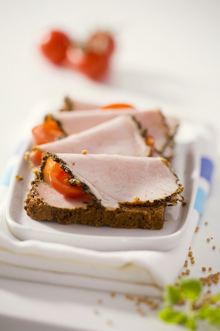 Ham with mustard crust and tomatoes on wholemeal bread
