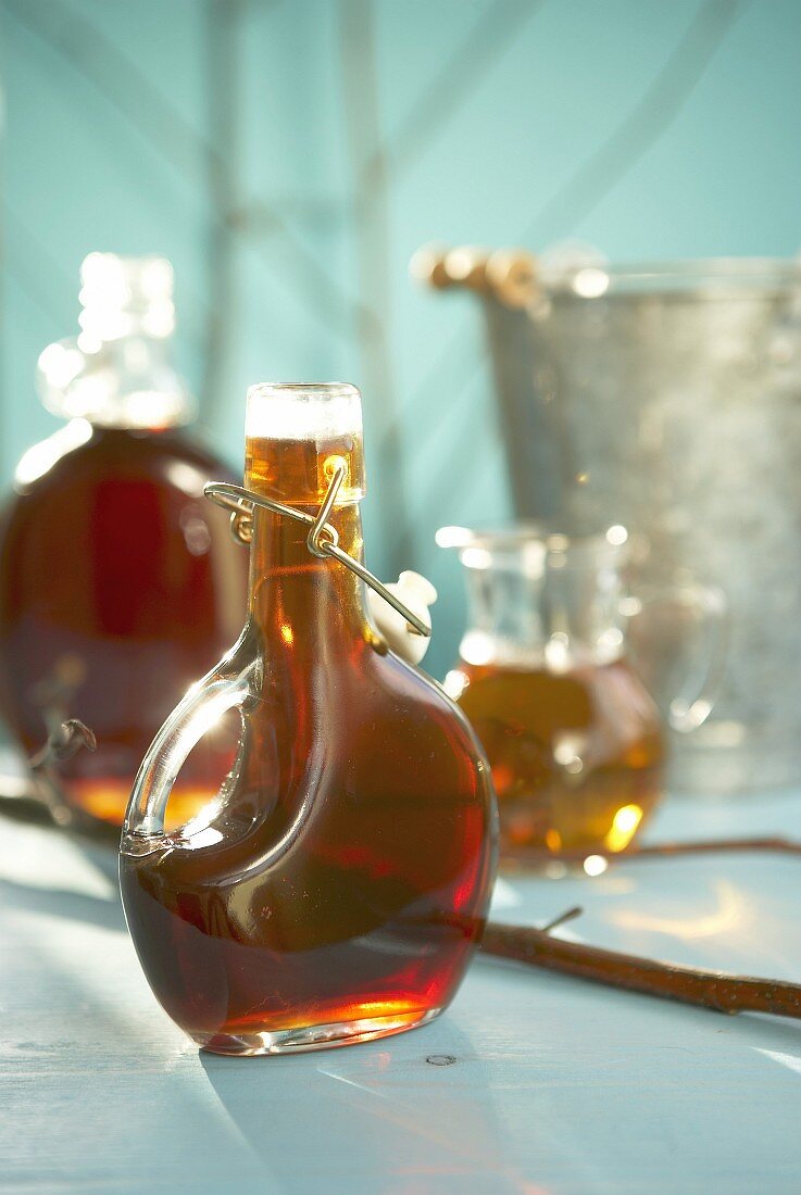 Maple syrup in bottles and small jug