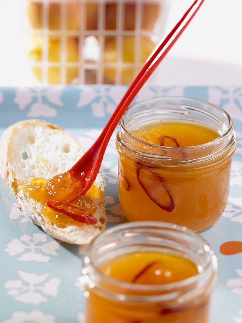 Zwei Gläser Aprikosen-Chili-Marmelade mit Löffel