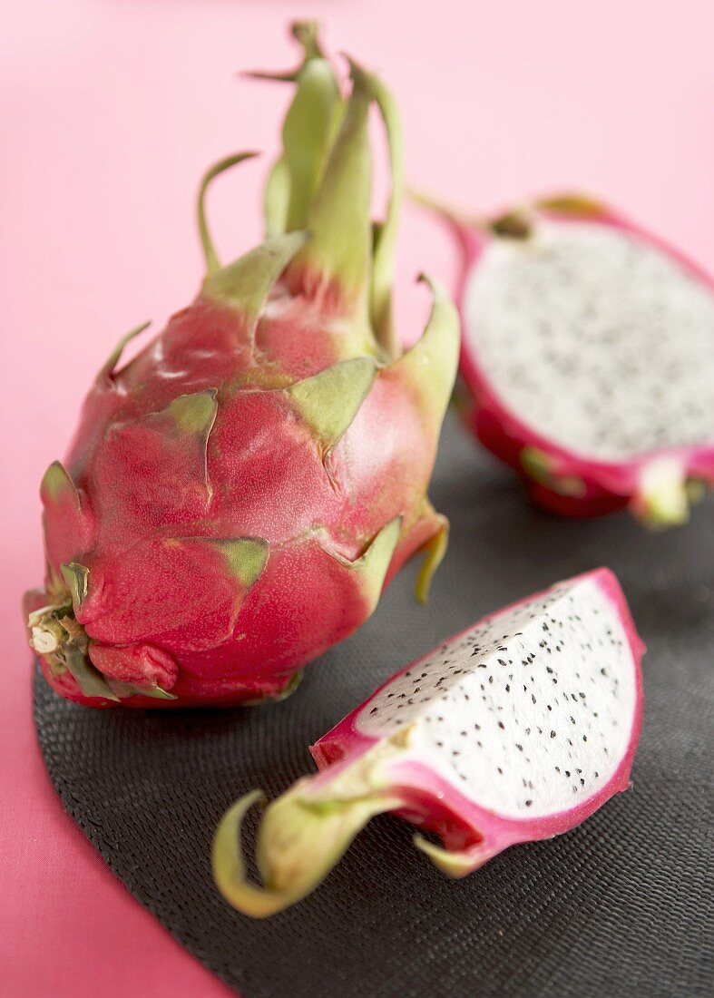 Pink dragon fruit, one whole and one cut open