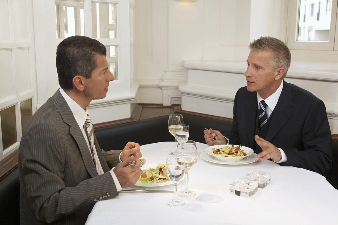 Two men having a discussion over lunch in a restaurant