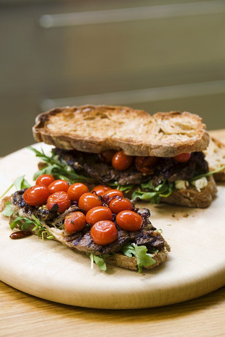 Steak sandwiches with fried tomatoes and rocket